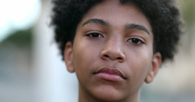 Ciddi bir melez çocuk kameraya bakıyor. Siyah etnik çocuk portresi