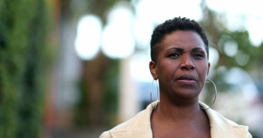 Dalgın bir Afrikalı kadın dışarıda yürüyor. 40 'lı yılların düşünceli siyahi insanı