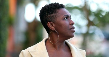 Dalgın bir Afrikalı kadın dışarıda yürüyor. 40 'lı yılların düşünceli siyahi insanı