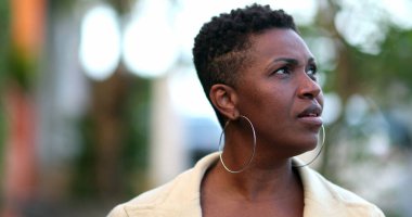 Dalgın bir Afrikalı kadın dışarıda yürüyor. 40 'lı yılların düşünceli siyahi insanı