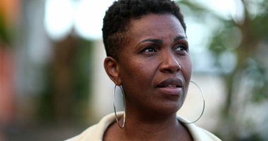 Sokakta yürüyen dalgın bir Afrikalı kadın. Düşünceli siyah bayan.