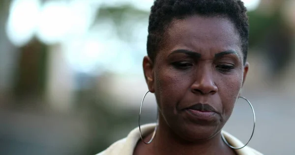 Sokakta yürüyen dalgın bir Afrikalı kadın. Düşünceli siyah bayan.