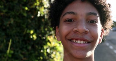 Genç bir çocuk sokak kaldırımında yürüyor. Melez ırk siyah ırk