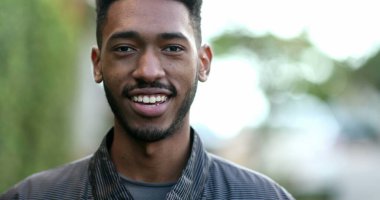 Genç Afrikalı adam ileri yürüyor. Siyahi kökenli, hareketli gülümseyen adam.