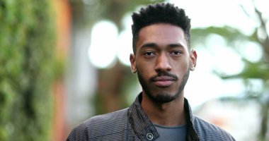 Genç Afrikalı adam ileri yürüyor. Siyahi kökenli, hareketli gülümseyen adam.