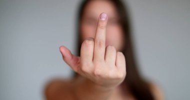 Kızgın genç kadın kameraya orta parmağını veriyor.