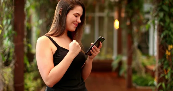 Woman Celebrates Good News Fist While Looking Cellphone Screen — Fotografia de Stock