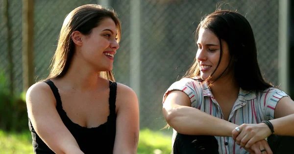 Two Female Friends Speaking Casually Young Women Chatting Outdoors Park —  Fotos de Stock