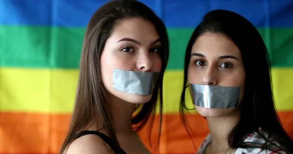 Portraits of two lesbian girlfriends unable to speak censored with duct tape in mouth, LGBT freedom of speech