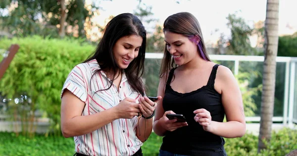 Young Women Standing Using Cellphone Device Smiling Laughing — Fotografia de Stock