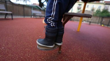 Little boy stepping down from playground structure steps equipment