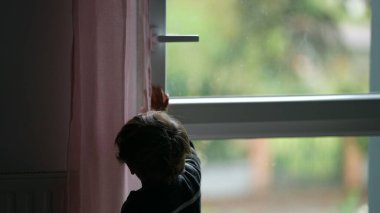 Little boy closing window. Child closes open window
