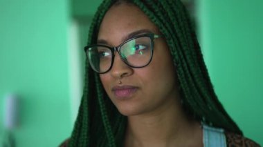 One young serious black woman with box braids hairstyle portrait face turning head to camera