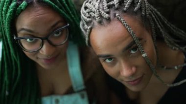 Two young black latina women with box braids hairstyle looking at camera. Braided cool hair style fashion portrait