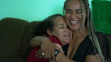 Mother and daughter laughing and smiling together. Two hispanic south american latin family laugh and smile