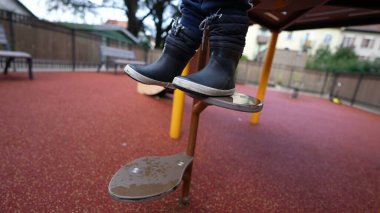 Little boy stepping down from playground structure steps equipment