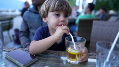 Child drinking from straw juice