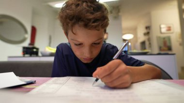 Okuldan sonra ödev yapan genç bir çocuk. Çocuk sınava hazırlanıyor.