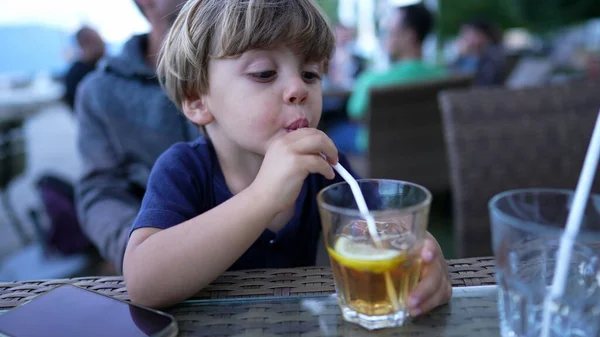 Child drinking from straw juice