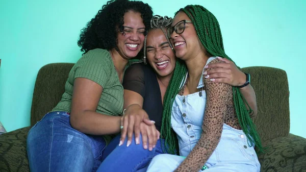 Joyful three black latina women laughing and smiling. Girlfriends embrace hanging out together