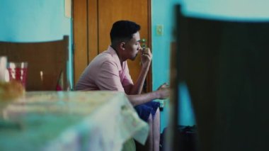 Candid pensive hispanic guy thinking at home. Casual south american person sitting indoors