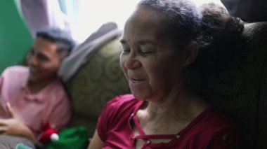A senior woman talking on phone laughing and smiling. A hispanic latin south american older person using cellphone