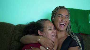 Mother and daughter laughing and smiling together. Two hispanic south american latin family laugh and smile