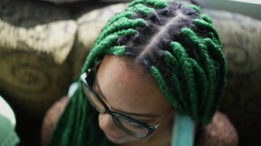 Box braided hairstyle. Green dreadlocks. One black latina young woman with fashion cool hair