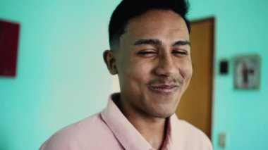 One young hispanic man holding laugh person trying not to laugh