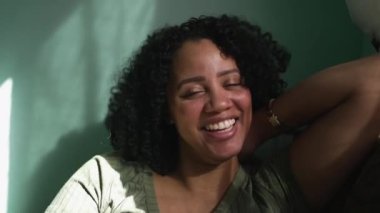 One Brazilian young woman laughing and smiling. A hispanic black girl feeling happy