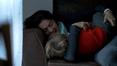 Candid mother and child love and affection. Mom grabbing toddler and filling with kisses