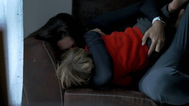 Candid mother and child love and affection. Mom grabbing toddler and filling with kisses