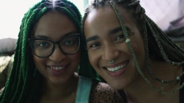 Two black latina young women portrait faces looking at camera