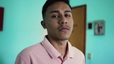 A serious hispanic young man portrait face looking at camera