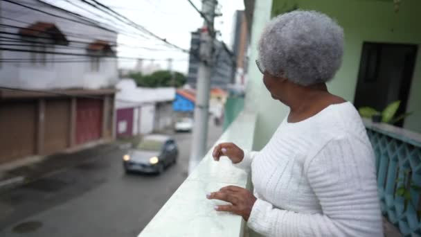 Senior Black Woman Looking Out Home Balcony Surveilling Neighborhood — ストック動画