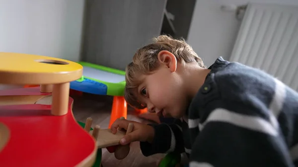 Toddler kid playing with toys in room