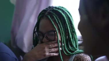 A young black woman laughing. One candid African girl laughs