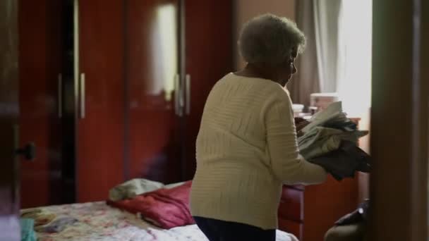 Een Senior Afrikaanse Vrouw Opruimen Kamer Verwijderen Kleren Uit Bed — Stockvideo