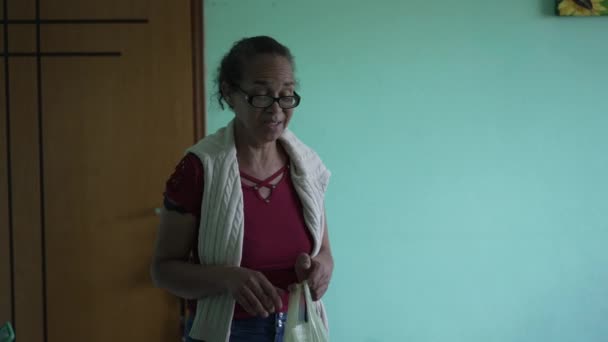 Hispanic Senior Woman Arriving Home Entering Kitchen Groceries — Stockvideo
