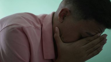 Depressed man in crisis. Sad unhappy person covering face suffering from mental illness