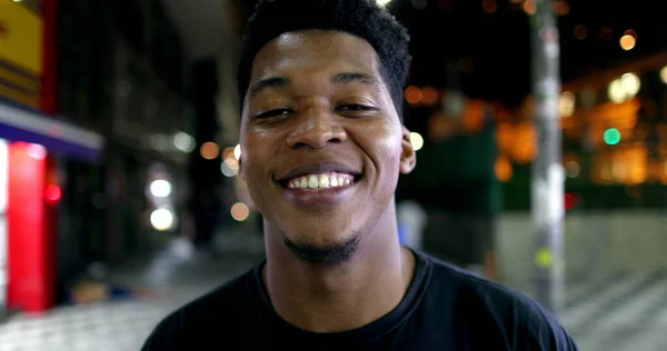 African man portrait smiling at night, looking at camera