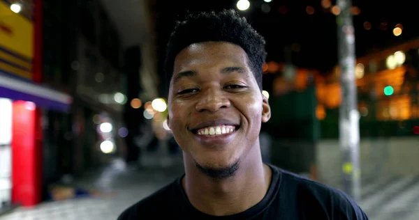 African man portrait smiling at night, looking at camera