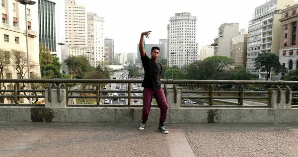 African artist performing urban dance in downtown city