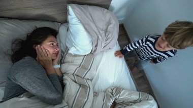 Authentic family morning bed, mother and child toddler waking up