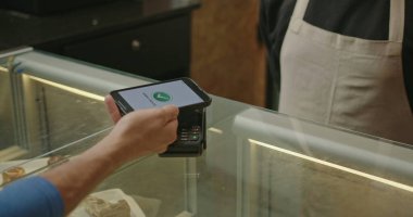 Temassız ödemeyle yakın çekimde telefonla ödeme yapmak. Bir restoranda NFC teknolojisi. Bir kahve dükkanında cep telefonu ödemesi.