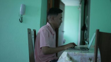 Young man using laptop at home. one hispanic person in front of computer screen online