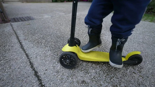 Child Legs Riding Toy Scooter Wearing Boots — Stockfoto