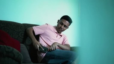 A hispanic man putting smartphone inside pocket pants. Latin person puts phone away