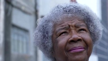 Düşünceli yaşlı bir kadın gökyüzüne bakıyor fırtınanın yaklaştığını hissediyor.