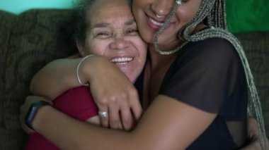 Adult daughter hugging older mother. An African girl embracing senior woman